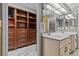 Bathroom with a sink and cabinets on the right, and a glimpse into a walk-in closet on the left at 1700 Hunter Ln, Tarpon Springs, FL 34689