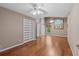 Large bedroom with hardwood floors, ceiling fans, and a bright window showcasing natural light at 1700 Hunter Ln, Tarpon Springs, FL 34689
