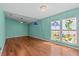 Bright bedroom with hardwood flooring, unique stained-glass windows, and a contemporary ceiling fan at 1700 Hunter Ln, Tarpon Springs, FL 34689