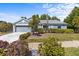 Charming home with mature landscaping, palm trees, and well-manicured lawn at 1700 Hunter Ln, Tarpon Springs, FL 34689
