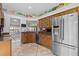 Kitchen with wood cabinets, stainless steel refrigerator, and granite countertops at 1700 Hunter Ln, Tarpon Springs, FL 34689