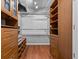 Organized walk-in closet with wood shelving, drawers, and hanging space for optimal storage at 1700 Hunter Ln, Tarpon Springs, FL 34689