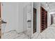 Bright walk-in closet with custom shelving, a full-length mirror, and elegant marble flooring at 1700 Hunter Ln, Tarpon Springs, FL 34689
