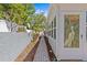 Charming walkway with decorative pavers leading to a side entrance featuring a door with stained glass art at 1700 Hunter Ln, Tarpon Springs, FL 34689