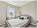 Cozy bedroom features a gray platform bed, white linens, and a sunny window view at 19370 Hawk Valley Dr, Tampa, FL 33647