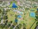 An aerial view shows a community pool, tennis court, playground, and lots of green space at 19370 Hawk Valley Dr, Tampa, FL 33647