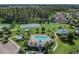 An aerial view shows a community pool, tennis court, playground, and lots of green space at 19370 Hawk Valley Dr, Tampa, FL 33647