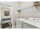 Functional laundry room includes a washer, dryer, wire shelving, and hall access at 19370 Hawk Valley Dr, Tampa, FL 33647