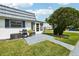 Rear facade shows a grill and outdoor seating on a patio, offering a relaxing outdoor space at 205 Andover N Pl # 110, Sun City Center, FL 33573