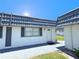Inviting condo featuring a blue roof, neutral siding, and well-maintained landscaping at 205 Andover N Pl # 110, Sun City Center, FL 33573