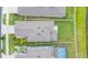 Birds-eye view of the backyard with green grass and neighborhood pool in the background at 20925 Monza Loop, Land O Lakes, FL 34638