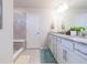 Bright bathroom featuring a granite countertop, double sinks, and white cabinetry for ample storage at 20925 Monza Loop, Land O Lakes, FL 34638