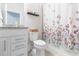 Clean bathroom features a vanity with granite countertop, decorative floral curtain, and shelf at 20925 Monza Loop, Land O Lakes, FL 34638