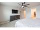 Sunlit bedroom with dark dresser, ceiling fan, and plush carpet at 20925 Monza Loop, Land O Lakes, FL 34638