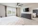Bright bedroom with large windows, dark dresser, and ceiling fan at 20925 Monza Loop, Land O Lakes, FL 34638