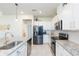 Spacious kitchen with stainless steel appliances, granite counters, white cabinets and tile flooring at 20925 Monza Loop, Land O Lakes, FL 34638