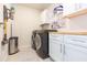 Functional laundry room with modern washer, dryer, and cabinet space at 20925 Monza Loop, Land O Lakes, FL 34638