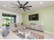 Relaxing living room boasts a large TV and sliding doors to the covered porch at 20925 Monza Loop, Land O Lakes, FL 34638