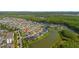 A neighborhood aerial view shows surrounding houses, ponds and roads, as well as proximity to a natural wooded area at 2121 Secret Cv, Odessa, FL 33556