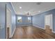 Bedroom with hardwood floors, blue walls, white trim, ceiling fan, and two windows at 2121 Secret Cv, Odessa, FL 33556