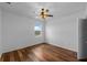Minimalist bedroom with hardwood floors, a ceiling fan, and natural light at 2121 Secret Cv, Odessa, FL 33556