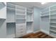 Walk-in closet with custom shelving, drawers, ample storage space, and hardwood flooring at 2121 Secret Cv, Odessa, FL 33556