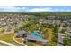 Aerial view of a community clubhouse and pool with palm trees, surrounded by homes and a lake at 2121 Secret Cv, Odessa, FL 33556