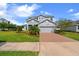 Charming two-story home with a well-manicured lawn, brick driveway, and a two-car garage at 2121 Secret Cv, Odessa, FL 33556