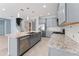 The kitchen boasts an island with sink and stone countertops, open to the living areas and staircase at 2121 Secret Cv, Odessa, FL 33556