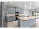 A spacious kitchen features gray cabinets, stainless appliances, granite countertops and a center island at 2121 Secret Cv, Odessa, FL 33556