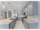 Spacious kitchen features granite countertops, gray cabinets, stainless steel appliances and a large kitchen island at 2121 Secret Cv, Odessa, FL 33556
