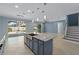 The kitchen boasts an island with sink and stone countertops, open to the dining and living areas at 2121 Secret Cv, Odessa, FL 33556