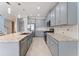 Open-concept kitchen with stainless steel appliances, gray cabinets, granite countertops, and large center island at 2121 Secret Cv, Odessa, FL 33556