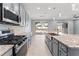 Features a spacious kitchen with gray cabinets, stainless appliances, granite countertops, and views of the pool at 2121 Secret Cv, Odessa, FL 33556