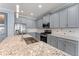 Modern kitchen boasts stainless steel appliances, gray cabinets, granite counters and a large island with sink at 2121 Secret Cv, Odessa, FL 33556