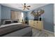 Staged bedroom with a plush bed, stylish decor, and a ceiling fan with light at 2121 Secret Cv, Odessa, FL 33556