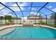 Beautiful pool area with a screened enclosure, mature landscaping, and a tranquil spa feature at 2121 Secret Cv, Odessa, FL 33556