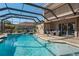 Beautiful screened-in pool with spa, waterfall feature, and outdoor seating area at 21604 Draycott Way, Land O Lakes, FL 34637
