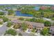 An aerial view of townhomes with lake view, garages, and lush green surroundings at 2441 Hibiscus Bay Ln, Brandon, FL 33511
