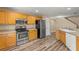 Functional kitchen with stainless steel appliances, wood cabinets, and durable wood-look flooring at 2441 Hibiscus Bay Ln, Brandon, FL 33511