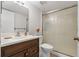 Bathroom featuring a wood vanity, white sink, toilet, and shower with glass door at 2699 Pine Ridge E Way # H1, Palm Harbor, FL 34684