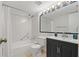 Bathroom with white tiled walls, combination shower and tub, and single sink vanity at 2699 Pine Ridge E Way # H1, Palm Harbor, FL 34684