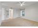 Bright bedroom with neutral carpet, closet, ceiling fan, and white walls at 2699 Pine Ridge E Way # H1, Palm Harbor, FL 34684