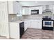Modern kitchen featuring white cabinets, stainless steel appliances, and granite countertops at 2712 60Th N Ave, St Petersburg, FL 33714