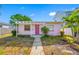 Charming single-story home featuring a vibrant pink exterior and well-lit front porch at 2827 1St Ne St, St Petersburg, FL 33704