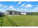 A view of the backyard featuring a concrete patio, grassy area, and a black metal fence at 3087 Forrest Plum Ct, Zephyrhills, FL 33540