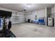 A spacious garage with a roll-up door and an overhead garage door opening mechanism and a water heater at 3087 Forrest Plum Ct, Zephyrhills, FL 33540