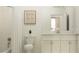 Bright bathroom with white subway tile, a white vanity with marble countertop, and a framed art piece above toilet at 31719 Griffin Sands Ln, San Antonio, FL 33576
