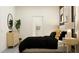 Bedroom featuring a bed with side tables and lamps, complimented by a round mirror and dresser on the opposite wall at 31719 Griffin Sands Ln, San Antonio, FL 33576