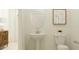 Charming powder room with a pedestal sink and toilet, decorated with modern wall art and a minimalist design at 31719 Griffin Sands Ln, San Antonio, FL 33576